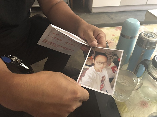  吴峰拿着女儿的照片