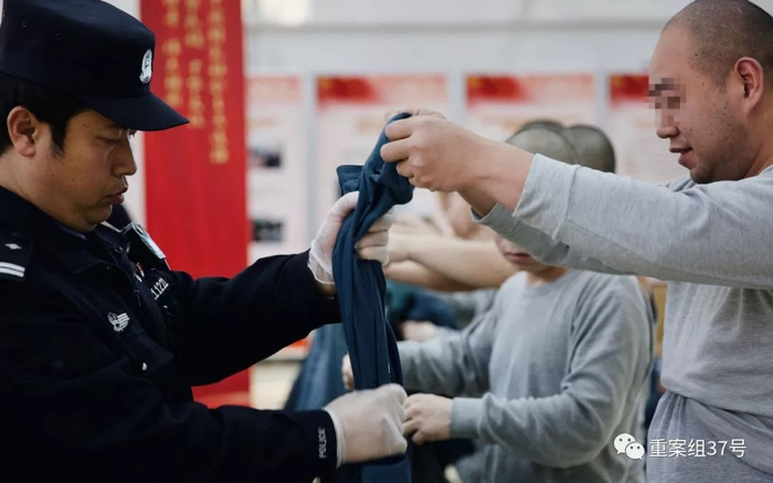 　　▲民警把犯人所穿的衣服鞋袜，包括可能藏有细小物品的耳朵、嘴巴，都挨个检查一遍，防止有夹带违禁物品。新京报记者 郑新洽 摄