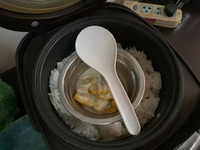  电饭煲里姐姐给吴德宏做的腌肉。新京报记者祖一飞&nbsp;摄