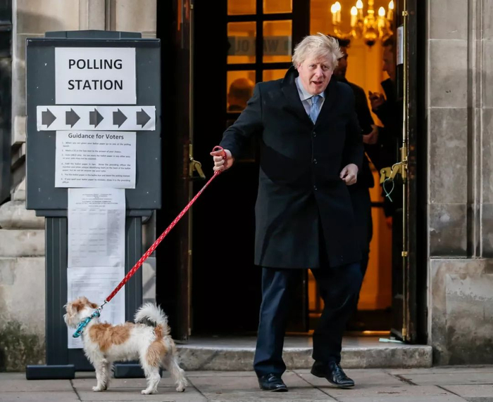 　　12月12日，在英国伦敦，英国首相、保守党领袖鲍里斯·约翰逊在一个投票站投票后牵着他的小狗离开。英国议会下院选举于当天上午7时开始投票。新华社记者 韩岩 摄