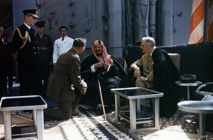 1945年，沙特国王阿卜杜勒阿齐兹与美国总统罗斯福在昆西号巡洋舰上秘密会面，商谈战后两国关系以及国际能源格局等问题。在国王右手边，一位美国军官单膝跪地汇报。