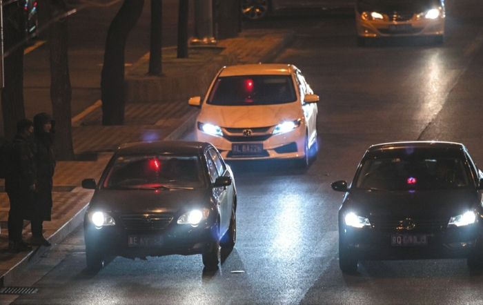  12月24日，工体北路，3辆车内悬挂红色小灯的车辆在揽客。新京报记者 陶冉 摄