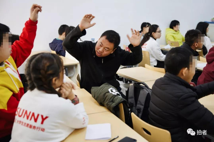 △&nbsp;12月7日，首都经贸大学，张弛在互动课堂上走了神，转身举手与身后的小伙伴互动。