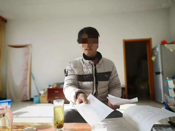2019年1月26日，张星（化名）在家中给记者展示他的就医资料和职业病诊断书等。新京报记者吴靖 摄