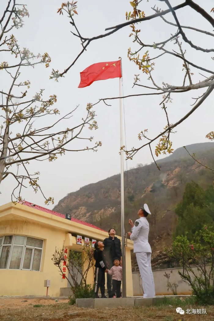 △北山哨所“守山人”、四级军士长赵克克一家四口在哨所升起国旗