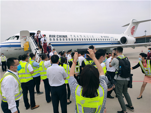 机组成员依次下飞机，大家纷纷上前拍照记录这一激动人心的时刻。