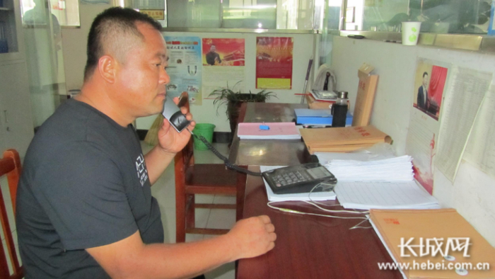 陈永明正在打电话，为贫困户的农副产品联系销路。  长城网记者 郭庆敏 摄