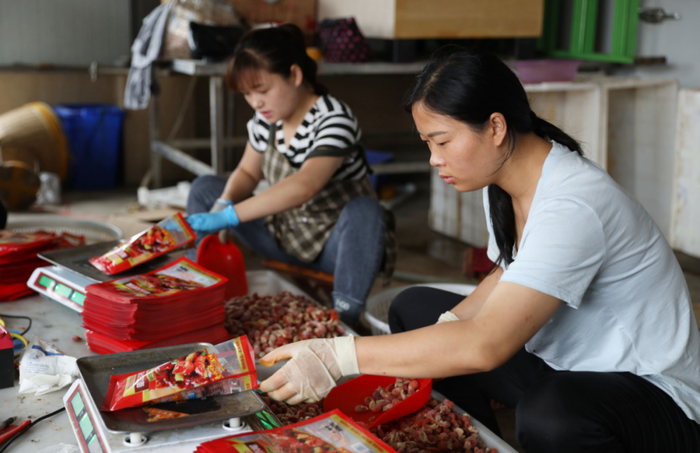 在连云港市海头镇，网络主播聘用的工作人员将小龙虾尾打包。（图片来源：新华社）