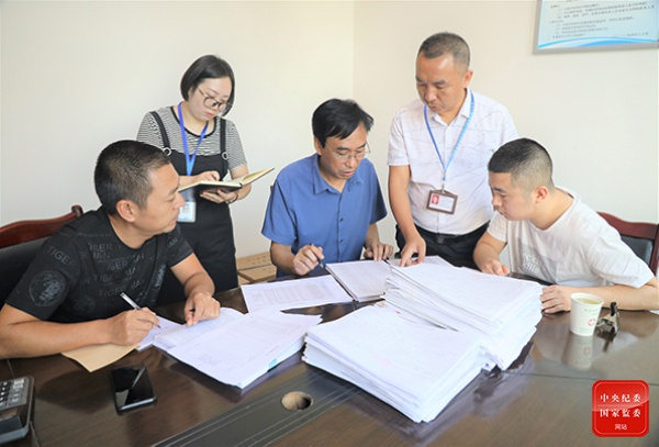 图为8月21日，广安市武胜县纪委监委工作人员在被监督单位检查耗材采购、管理、发放及使用台账资料，排查问题线索。