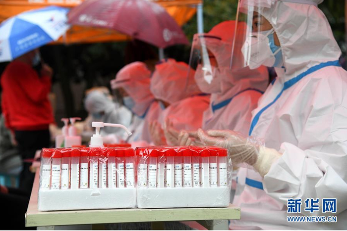 ▲10月14日，工作人员在青岛市市北区海伦路街道一检测点为市民进行核酸检测采样。