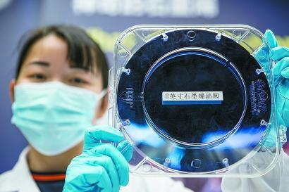 研发人员展示8英寸石墨烯单晶晶圆。 赖鑫琳 摄
