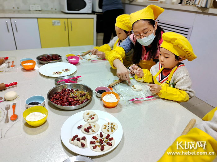 小朋友们在老师的带领下制作重阳糕。