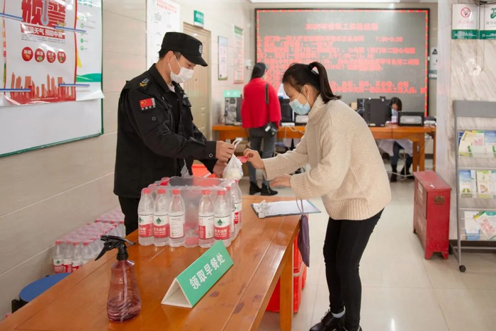 ▲一名教职工领取体检早餐（彭雨格 摄）