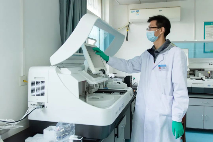 ▲校医院杨晓庆医生设置肿瘤标志物检测仪参数（彭雨格 摄）