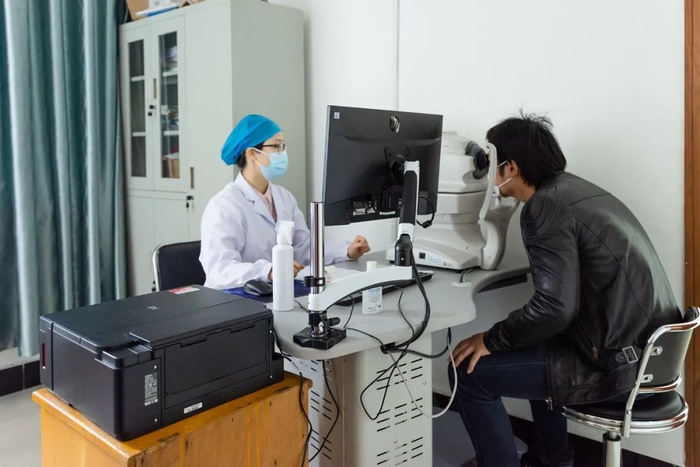 ▲医护人员为教职工检查眼底（彭雨格 摄）