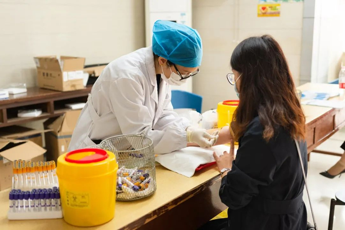 ▲医护人员为教职工采集血样