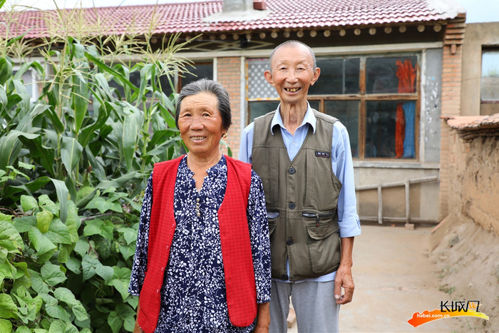 刘俊（右）和老伴黄秀果在自家小院里。