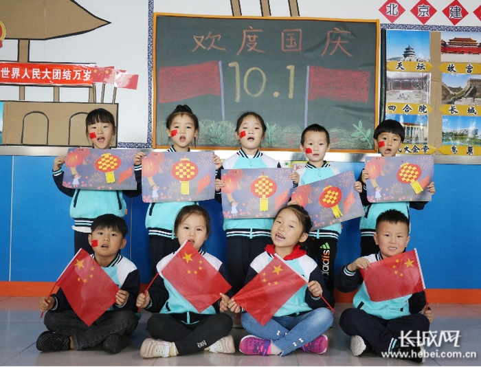 在河北省广宗县阳光幼儿园，小朋友们手捧小国旗和高唱国歌喜迎国庆节的到来。  梁智晓 供图