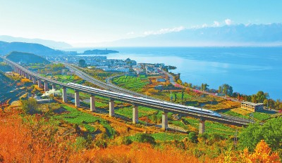     和谐号动车组列车奔跑在洱海边。付世凯摄/光明图片