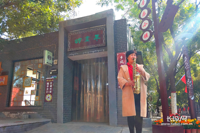 郭玉管在年画坊门前吹响萨克斯。长城网记者 张千 摄