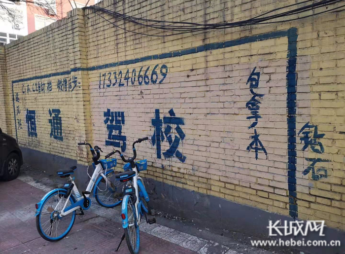 驾校在墙上印刷广告。网友供图