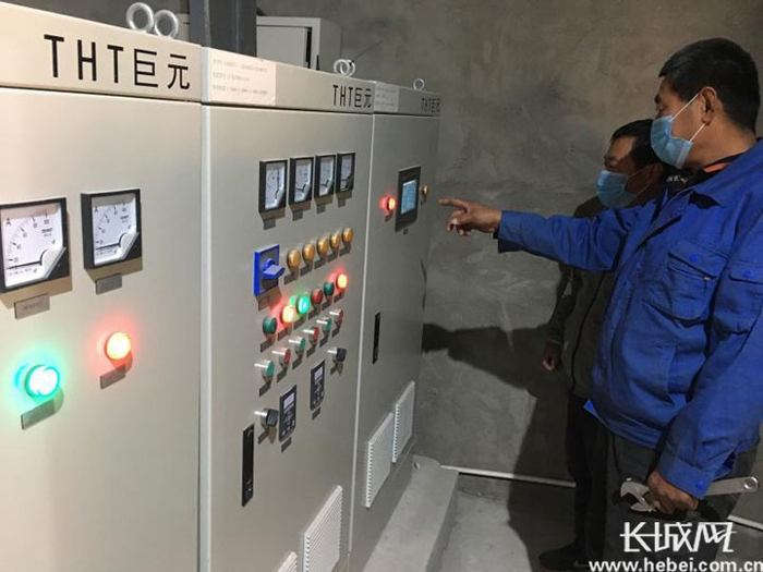 小区换热站工作人员对各项数据认真查看。郄晓强 摄