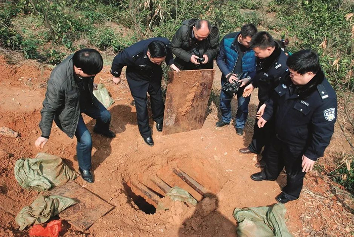 2014年3月，湖南常德临澧县公安局民警和临澧县文物局执法大队工作人员在被盗墓穴现场勘查。图/新华