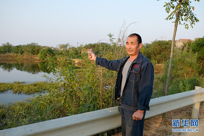 陈伦安在承包的鱼塘边。新华网李征峥 摄
