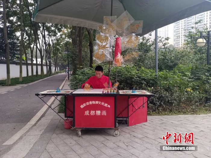 身着红色上衣的吴毅正在专心作画。祝欢 摄