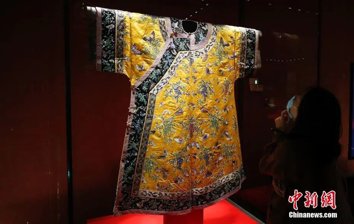 图为观众参观"明黄色缎绣藤萝纹夹衬衣（清光绪）"。中新社记者 杜洋 摄