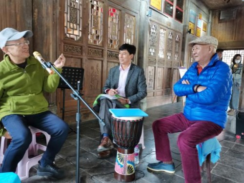 中国作协名誉主席丹增与著名作家赵晏彪在风雨廊桥边采访做公益的乐手