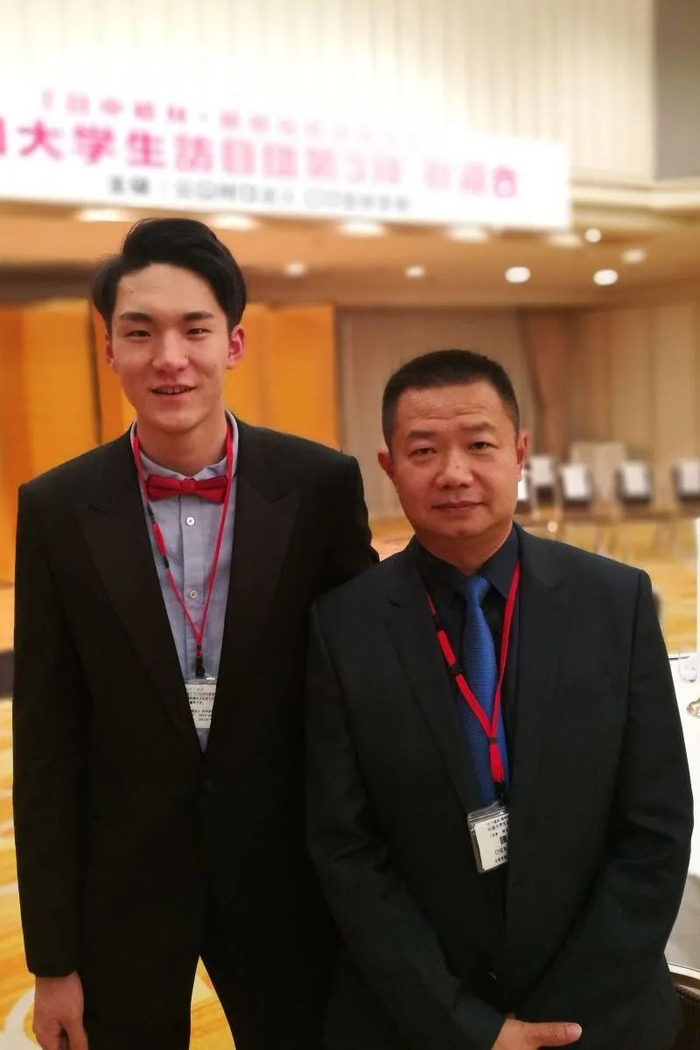 ▲武弸智（左）、我校男排教练陈星飚（右）合影