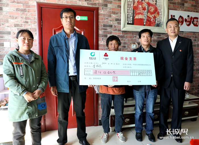 安国市卫健、国寿工作人员为村民送理赔款。 长城网记者 烟成群摄