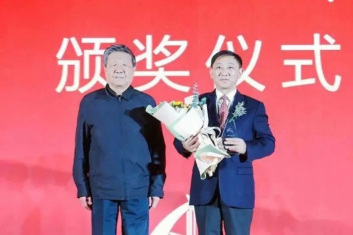 ▲中国公路学会七届理事会理事长胡希捷为熊国斌校友颁奖