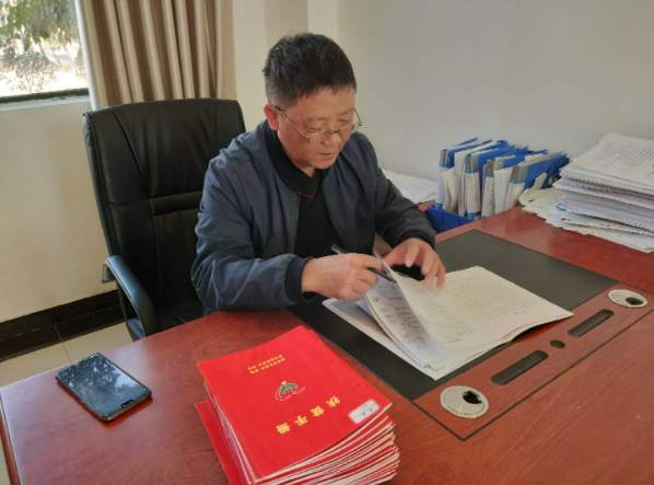 图为周国良同志正在核查扶贫手册信息