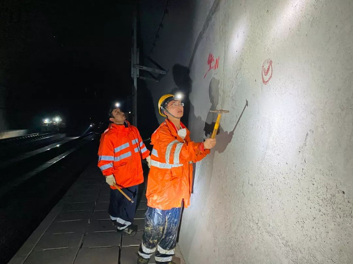 刘俊手持锤子检查山体