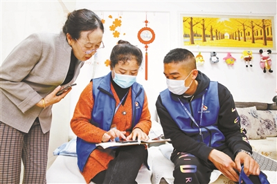 11月1日，连云港市连云区墟沟街道的普查员李莎（中）通过手机人口信息采集系统现场登记供图/新华社