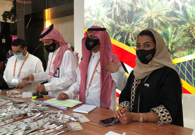 G20峰会新闻中心现场，年轻的志愿者佩戴着印有G20标识的口罩