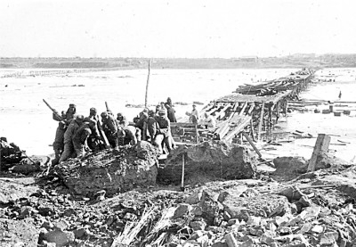  ④&nbsp;抗美援朝时期，中国人民志愿军的工兵战士们抢修被敌机炸毁的渡桥（资料照片）。&nbsp;新华社发