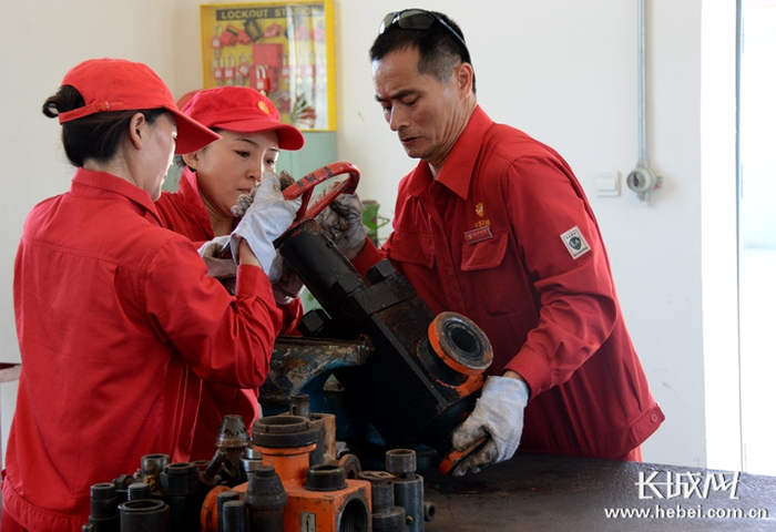 黄京生（右）和同事们研究设备创新。杨伟奉 贺丽伟 杜慧 刘明 摄