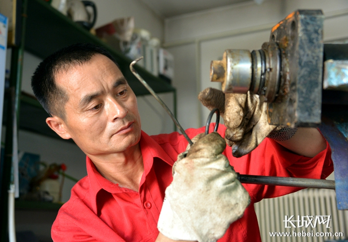 黄京生在工作室修旧利废。杨伟奉 贺丽伟 杜慧 刘明 摄