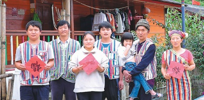 　　独龙江乡巴坡村村民在自家门前合影。　　杨时平摄