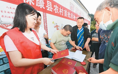 　　今年8月以来，湖北省襄阳市保康县农村不动产确权登记发证工作全面启动。图为工作人员正在向保康县龙坪镇川山村村民发放农村房地一体不动产权证书。　　陈泉霖摄（人民视觉）