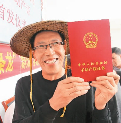 　　浙江省临海市杜桥镇切实抓好农房确权工作，上门为群众办理不动产权证书。图为杜桥镇勤横湖村村民展示拿到的不动产权证书。　　蒋友青摄（人民视觉）