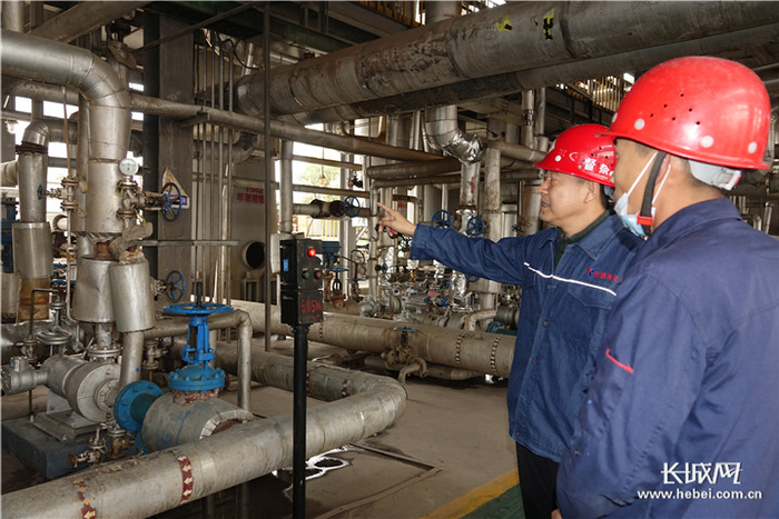 郝金民（左）在车间指导工作。长城网记者 张谢雅 摄
