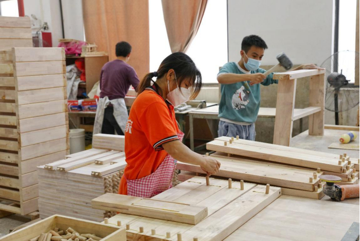 ▲联圆世家工人正在组装一款最具性价比的中式实木沙发。