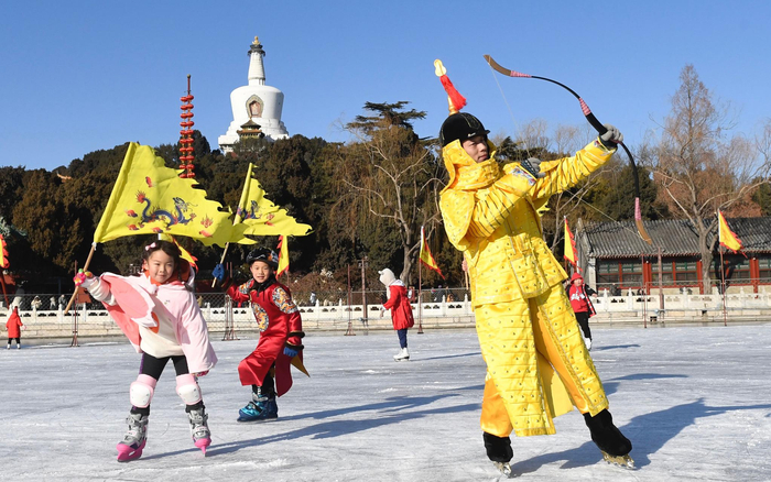 “冰嬉”演员和身着少年冰嬉服的小朋友互动。摄影/新京报记者 吴宁