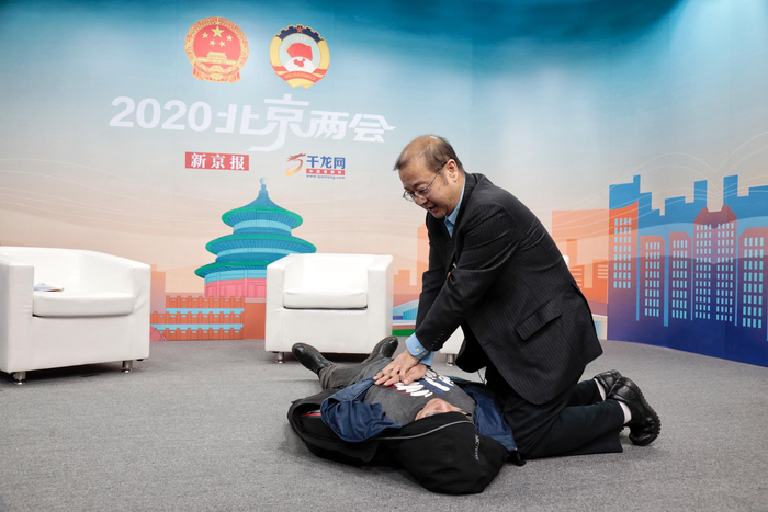 市人大代表熊辉现场向记者演示心肺复苏。 摄/新京报记者 王嘉宁