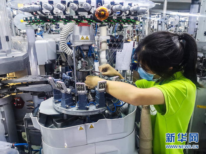 工人在袜业扶贫车间智能袜机生产线上作业。新华网 张潘 摄