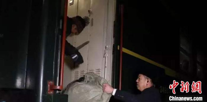 图为旅客在列车员帮扶下下车。(李玉祥 宁国军 摄)